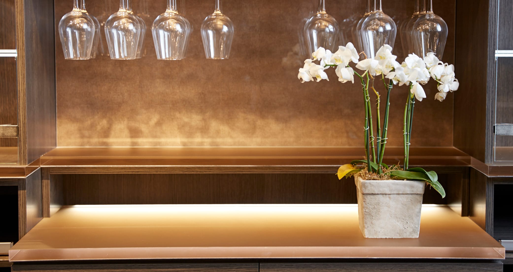 Home wine bar glassware storage details with ecoresin design on back wall and led lighting by California Closets