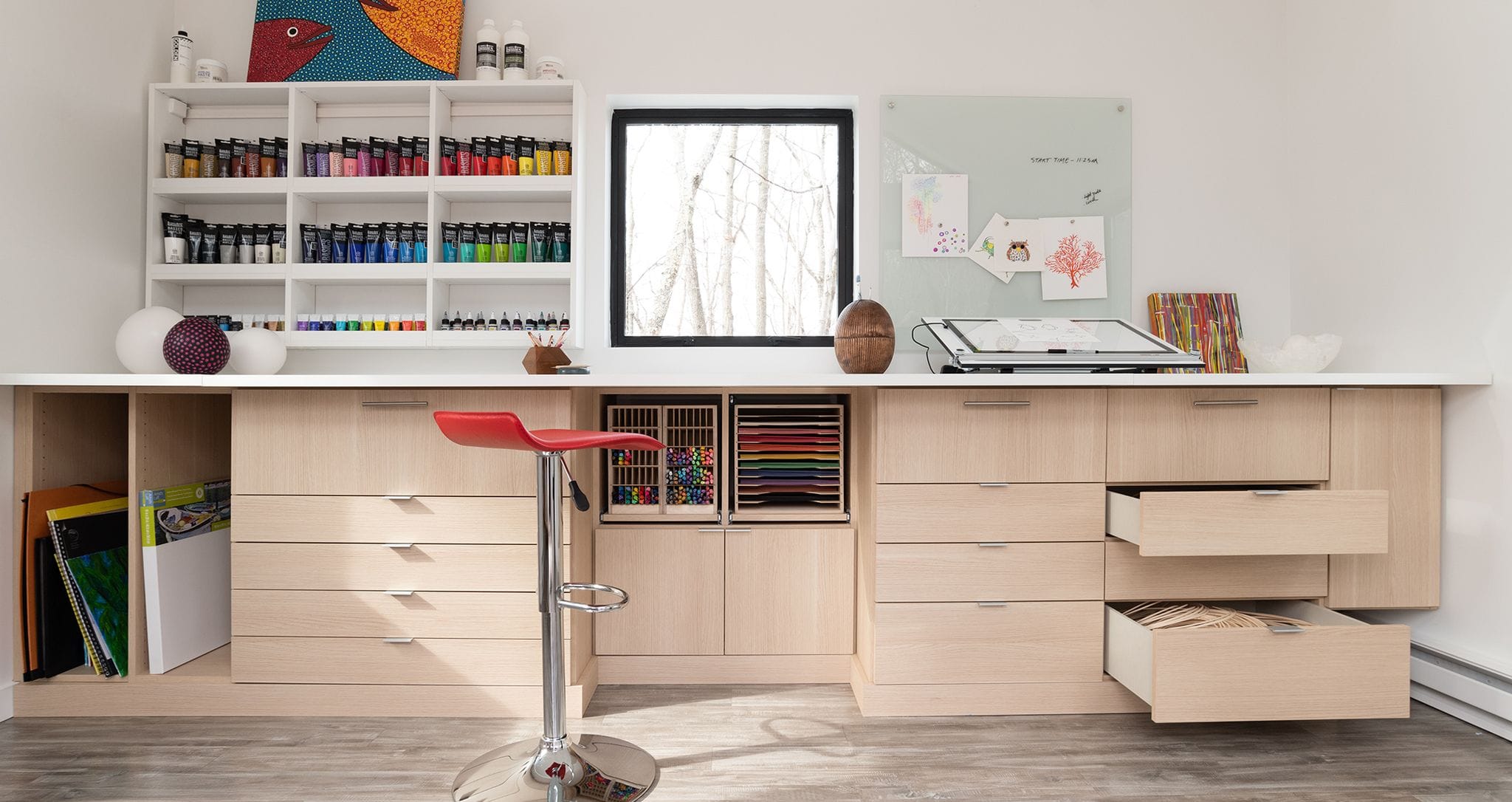 Custom craft room designed for artist in a stand-alone studio with big desk and countertops by California Closets
