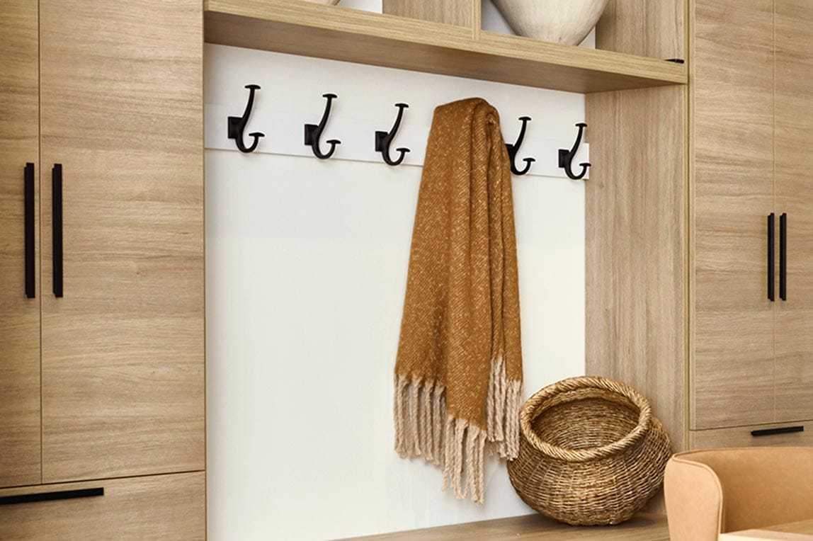 Entryway accessories with hooks for coats, ties, and belts designed by California Closets