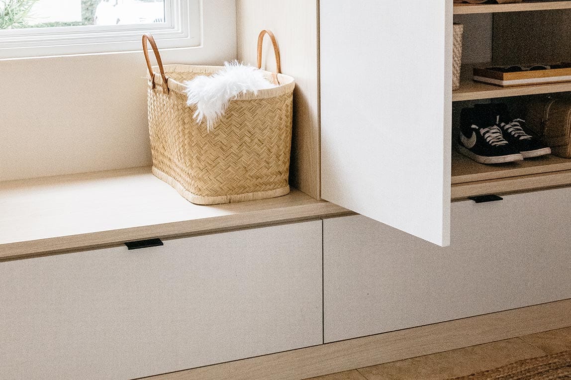 Custom cabinet, drawer and bench for mudroom entry created by California Closets