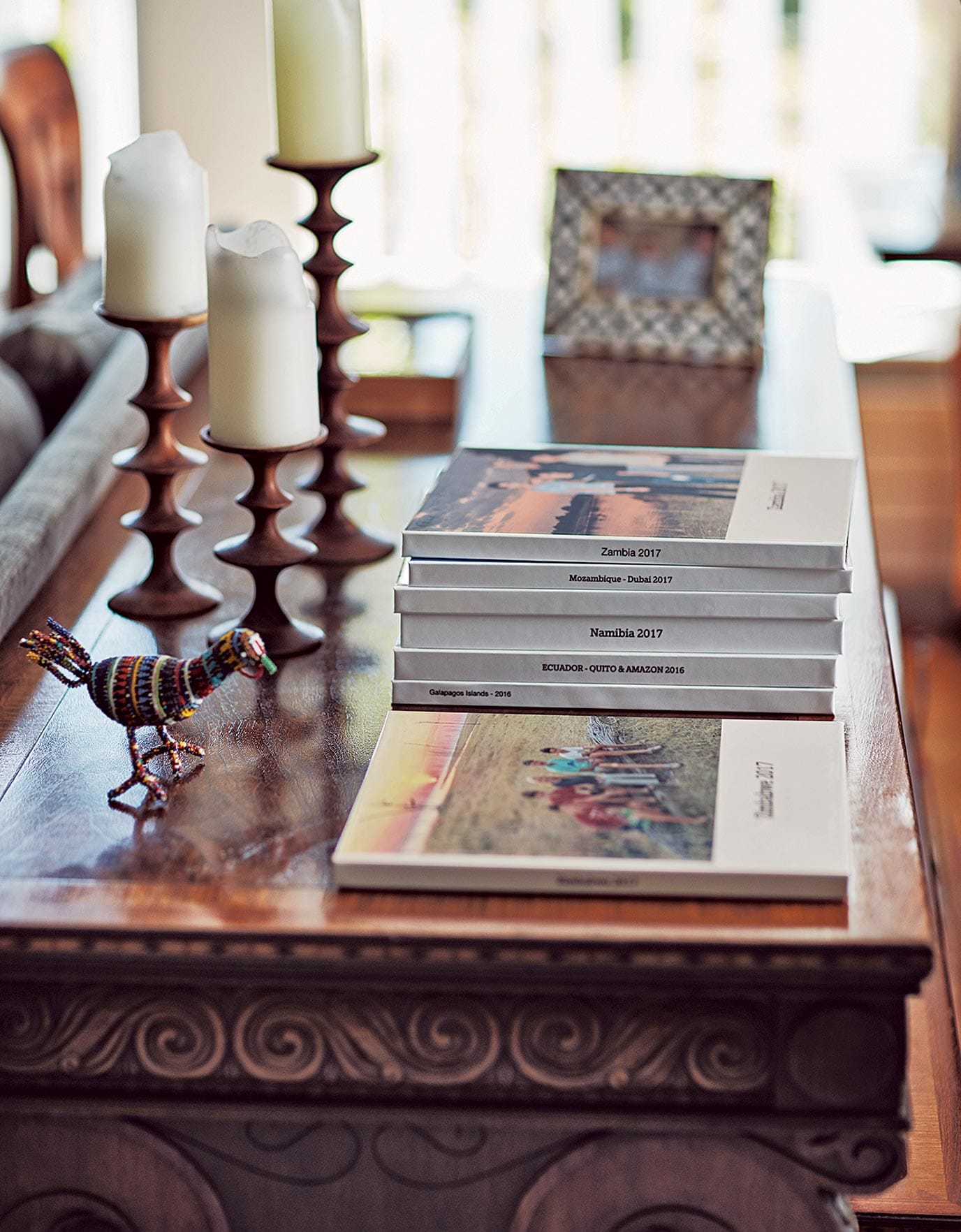 Family photo albums from Kenya, Inda and Zambia adorn a coffee table as seen in California Closets Ideas of Order Magazine